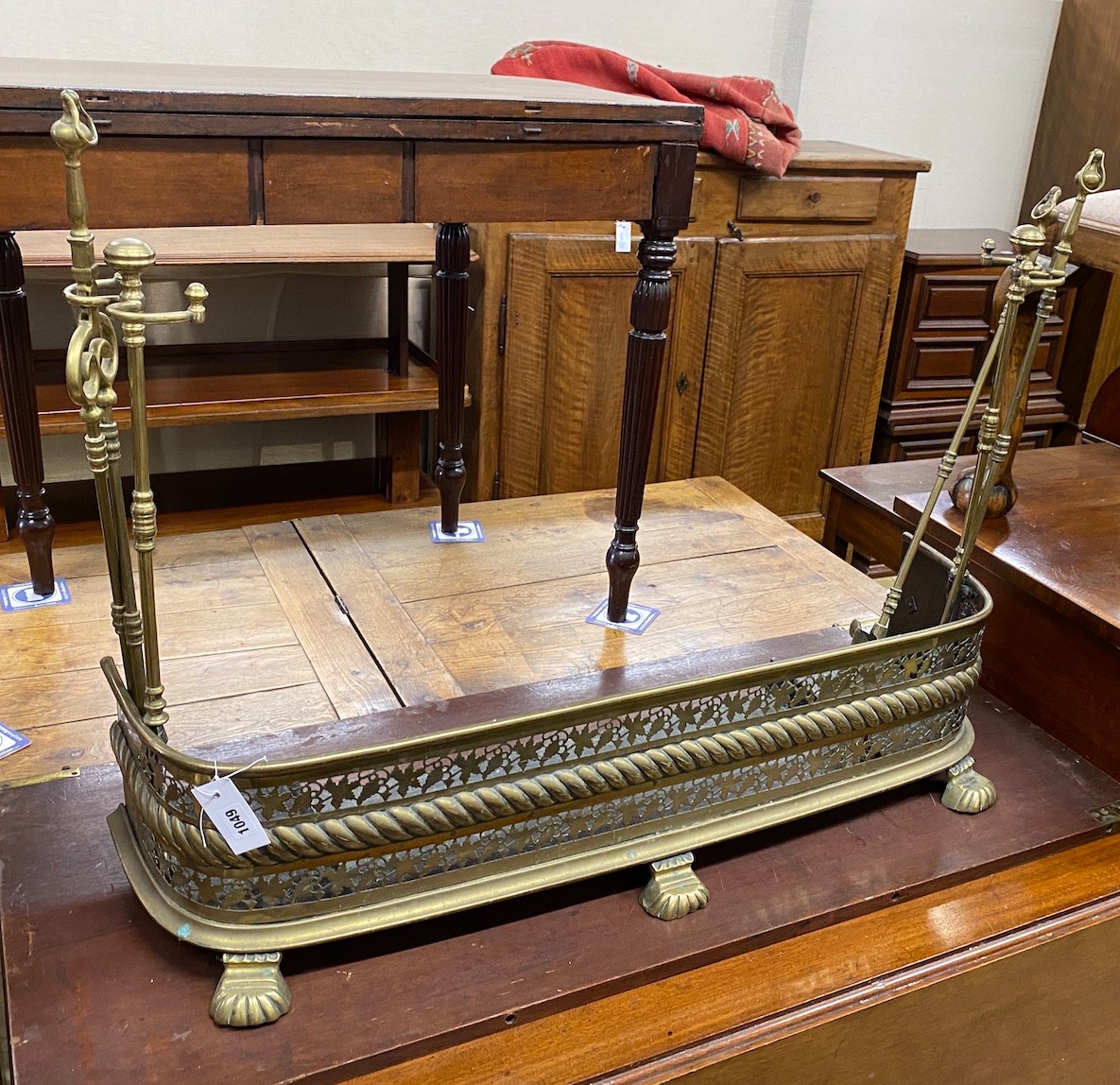 A Victorian pierced brass fender, length 98cm, height 23cm together with companion set